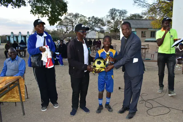 A young footballer receiving a prize from officials