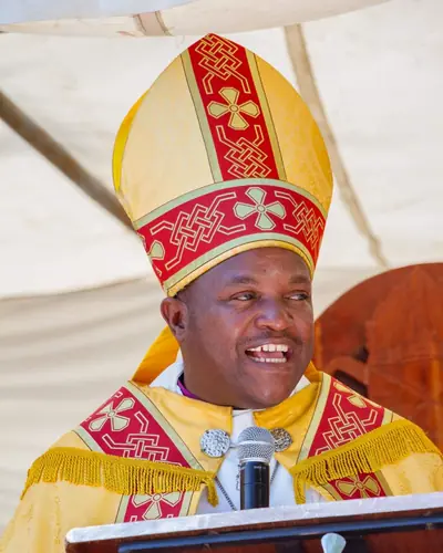The Bishop of Harare smiling in his mitre and vestments at a pulpit