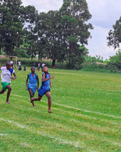 Learners sprinting down a grass running track on sports day